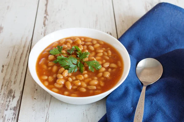 Frijoles en salsa de tomate en un tazón de porcelana blanca —  Fotos de Stock