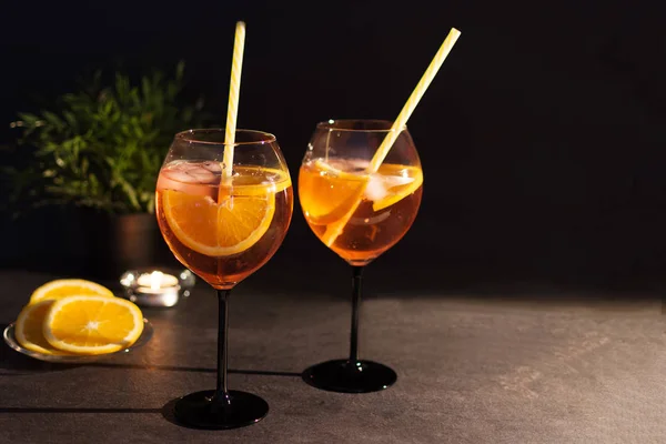 Zwei Gläser Aperol Spritz Cocktail mit Orangenscheiben auf schwarzem Hintergrund. — Stockfoto