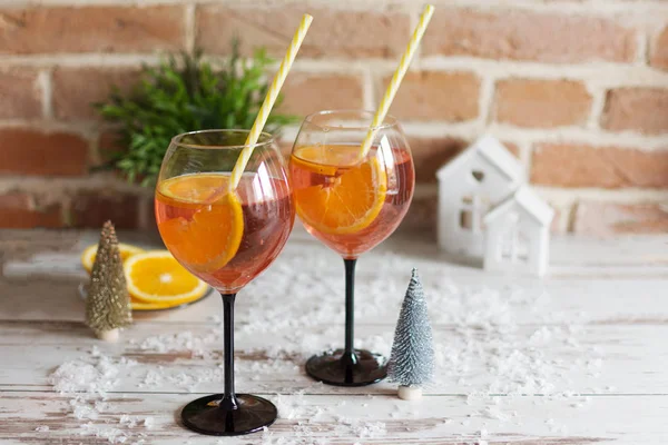 Ahşap arka planda portakal dilimleri ile rossini prosecco kokteyl iki bardak.