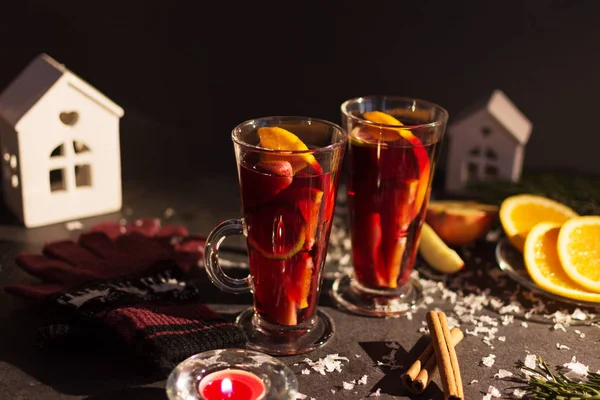 Svateční víno s plátkem pomerančů, jablek a koření na vánočním pozadí s různou výzdobou. — Stock fotografie