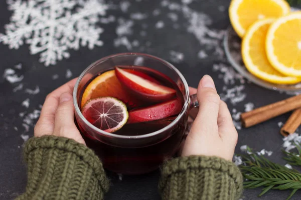 Woman holding a glass cup of hot Christmas mulled wine in hands, closeup. — Stock Photo, Image