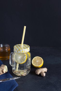 Siyah zemin üzerinde limon detoksu olan zencefil.