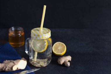 Siyah zemin üzerinde limon detoksu olan zencefil.