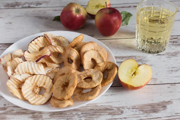 Gedroogde appelringen en chips in vergelijking met verse rode appels. — Stockfoto