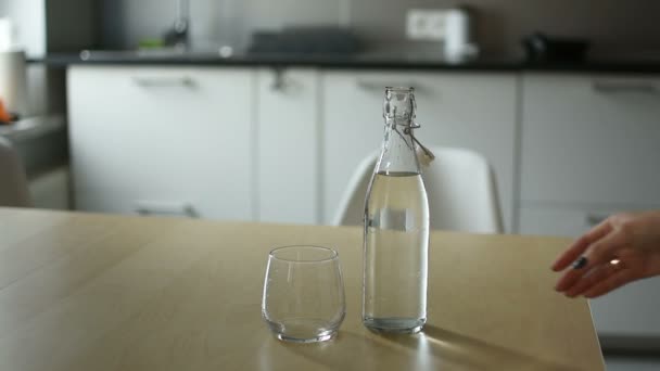 Kvinna Hand Hälla Kallt Vatten Från Flaska Träbord Över Kök — Stockvideo