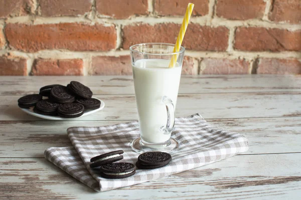 Biscoitos de chocolate doce com creme de baunilha e um copo de leite . — Fotografia de Stock