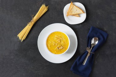 Arka planda spagetti ve tavuk eti ile krem peynir çorbası..