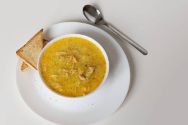 Makarnalı krem peynir çorbası ve beyaz arka planda tavuk eti..