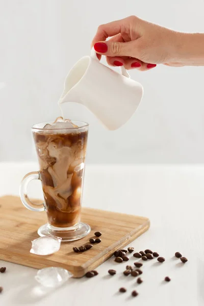 Café gelado em um copo alto com creme derramado sobre . — Fotografia de Stock