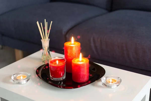 Palos de refresco de aire de la habitación y velas rojas ardientes en la mesa en el interior moderno hogar . —  Fotos de Stock