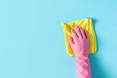 Mavi masayı temizlemek için plastik koruyucu eldiven ve mikrofiber bez getirin. Temizlik şirketi konsepti.