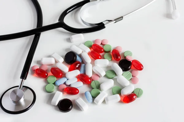 Doktorun Steteskopuyla Beyaz Arka Planda Bir Sürü Renkli Ilaç Var — Stok fotoğraf