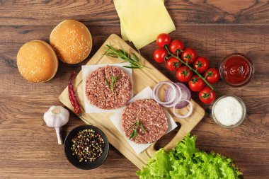 Ahşap arka planda ev yapımı hamburger için taze hamburgerler. Sağlıksız yemek, fast food yemeği..