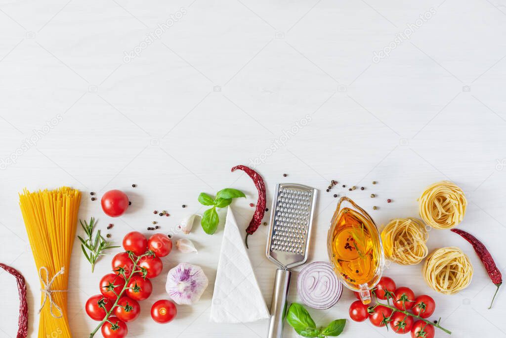 Italian pasta ingredients for cooking. Raw pasta, cheese, vegetables, spices and herbs top view on white wooden background. Italian healthy vegan food.