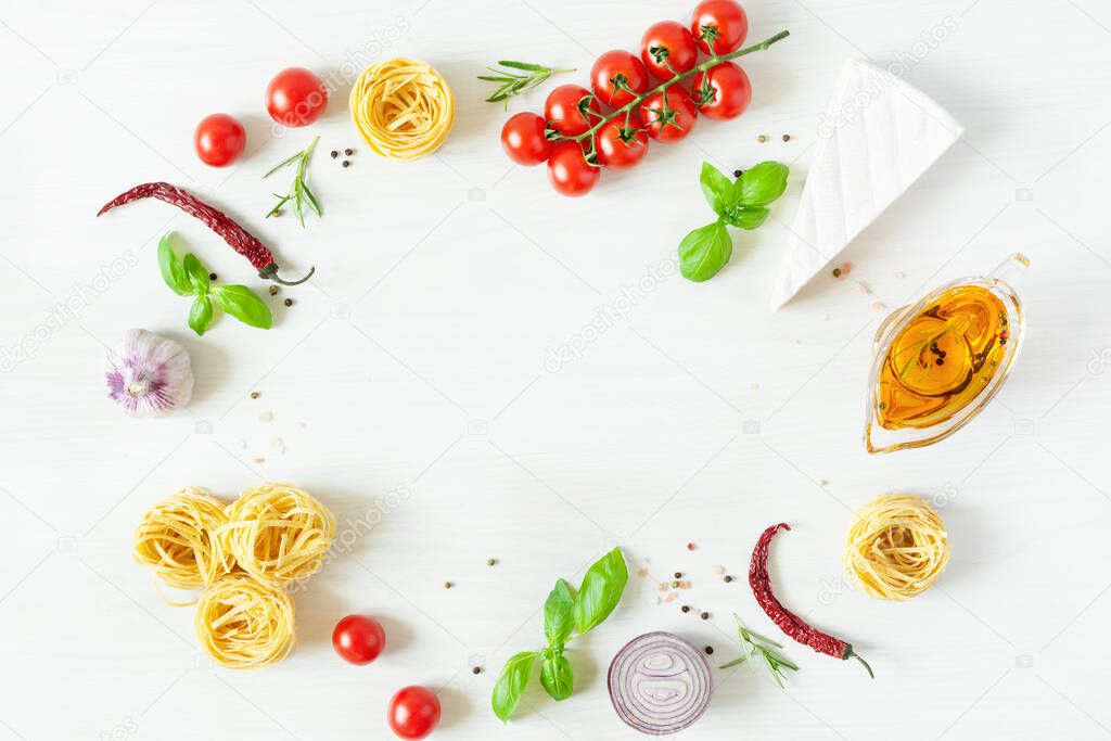 Frame of italian pasta ingredients for cooking. Raw pasta, cheese, vegetables, spices and herbs top view on white wooden background. Italian healthy vegan food.