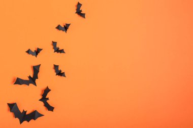 Cadılar Bayramı arka planında turuncu arka planda uçan yarasalar var. Cadılar Bayramı tebrik kartı.