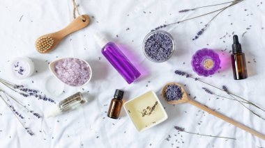 Beyaz arka planda çeşitli organik lavanta kozmetik ürünleri. Lavanta çiçekli bitkisel kozmetik.