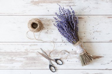 Güzel kurutulmuş lavanta çiçekleri beyaz ahşap arka planda üst manzarayla doludur. Retro biçimi.
