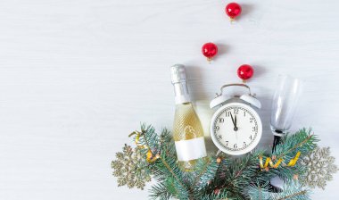 Şampanya şişesi, köknar dalları ve beyaz ahşap arka plan manzaralı Noel süslemeleri. Yeni yıl, Noel tebrik kartı..