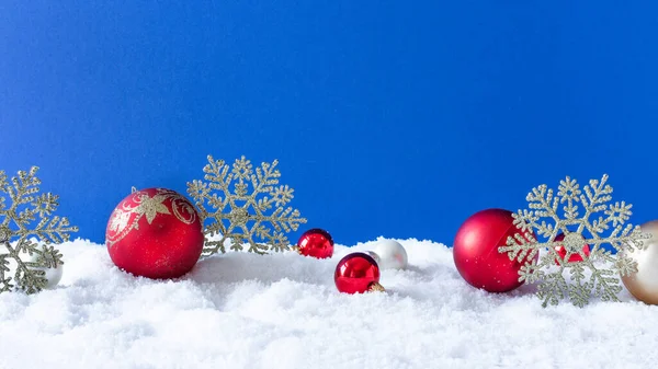 青い背景に雪の上のクリスマスの装飾 コピースペースと冬のクリスマスの背景 — ストック写真