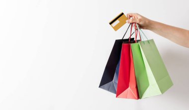 Renkli kağıt alışveriş torbaları ve beyaz arka planda kredi kartı taşıyan bir kadın grubu. Alışveriş afişi konsepti.