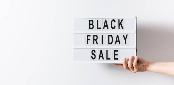 Женщина держит светильник с черным пятничным текстом на белом фоне. Фон "черной пятницы" для оформления рекламы рекламодателей и рекламодателей. 