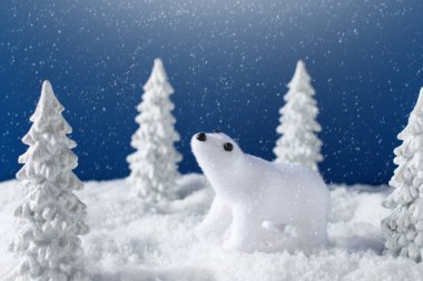 Beyaz ayılı kış kartı, karlı köknar ağaçları ve mavi gökyüzü. Yeni yıl ve Noel tebrik kartı tasarımı.