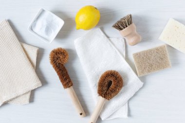 Çevre dostu bambu fırçaları ve beyaz ahşap arka plandaki üst manzarayı temizlemek için kabartma tozu ile limon. Sıfır atık. Plastik ve kimya ücretsiz. 