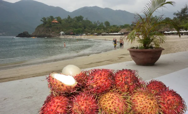 Tray with litchi fruit on the beach background