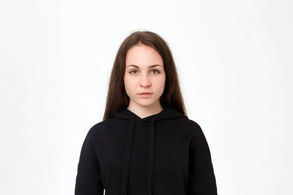 Beyaz arka plan önünde duran siyah bir sweatshirt güzel bir genç kadın portresi — Stok fotoğraf