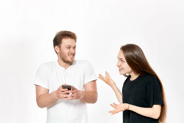 Photo studio d'un jeune couple en train de se disputer. Femme est bouleversée que l'homme utilise le téléphone tout le temps sans prêter attention à elle . — Photo