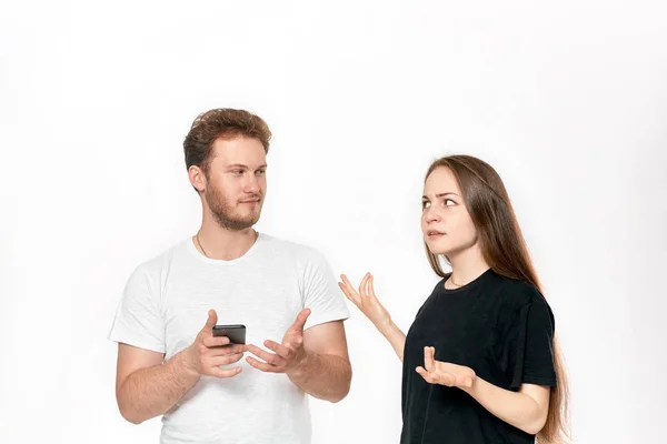 Photo studio d'un jeune couple en train de se disputer. Femme est bouleversée que l'homme utilise le téléphone tout le temps sans prêter attention à elle . — Photo