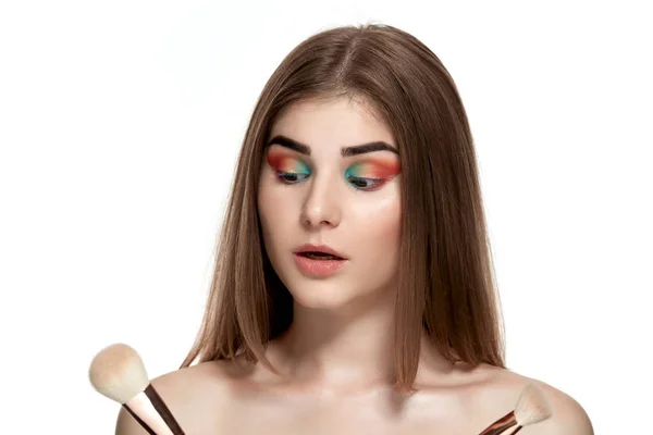 Retrato de cerca de una hermosa joven con pinceles para maquillaje — Foto de Stock