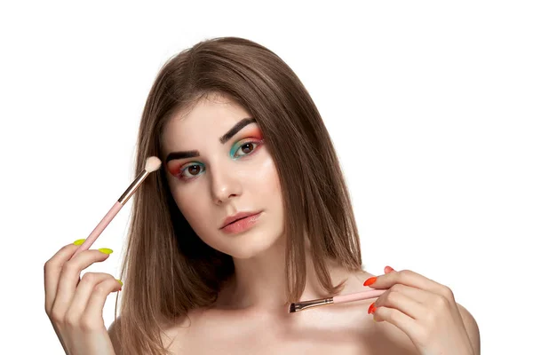 Retrato de close-up de bela jovem com escovas para maquiagem — Fotografia de Stock