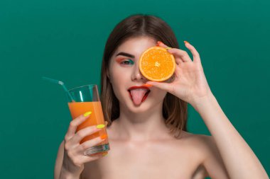 Parlak renk makyaj portakal suyu içme ile güzel genç kadının Closeup portre