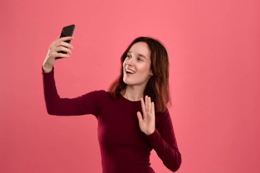 Bir cep telefonu ile selfie yapan güzel bir genç esmer kadın fotoğrafı 