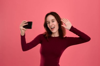 Bir cep telefonu ile selfie yapan güzel bir genç esmer kadın fotoğrafı 