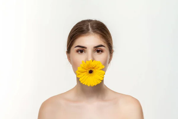 Ritratto ravvicinato di una bella ragazza con fiore giallo isolato su sfondo bianco . — Foto Stock