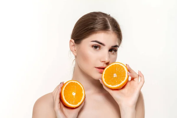 Close-up retrato de uma bela menina feliz segurando metade das laranjas perto do rosto isolado sobre fundo branco . — Fotografia de Stock