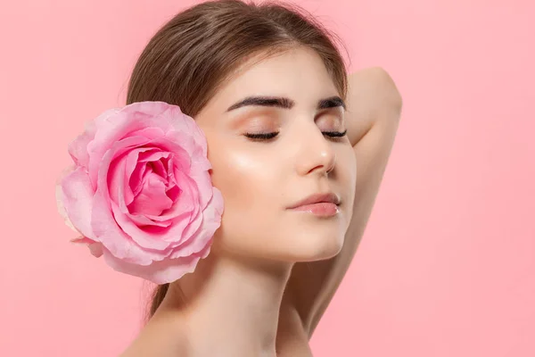 Retrato de cerca de una hermosa joven con rosa rosa aislada sobre fondo rosa . — Foto de Stock