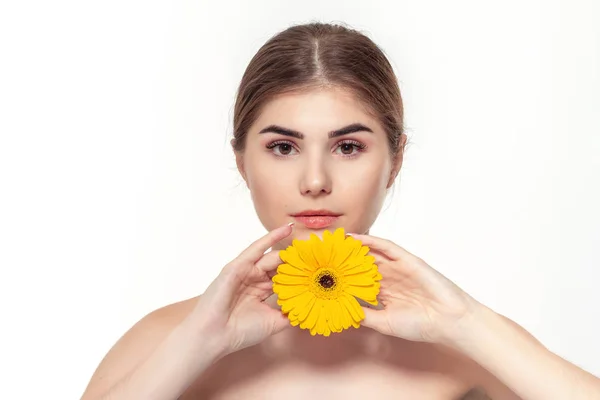 Retrato de cerca de una hermosa joven con flor amarilla aislada sobre fondo blanco . — Foto de Stock