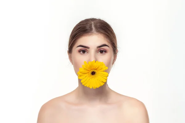 Retrato de cerca de una hermosa joven con flor amarilla aislada sobre fondo blanco . — Foto de Stock