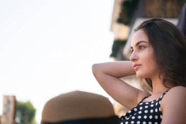 Siyah elbise giymiş güzel genç esmer kadın yabancı ülkelerde seyahat sıcak yaz aylarında bir kafede dinleniyor