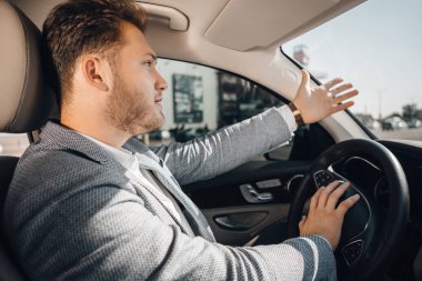 Trafik sıkışıklığındaki kızgın sürücü kurcaladığını ve arabasını bırakmak için gesturing.