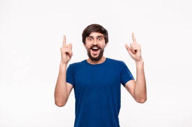 Sakallı mavi gömlekli yakışıklı brunet adam ve bıyıkları parmaklarıyla beyaz arka plan üzerinde izole ayakta işaret. Ürün ve reklam yeri.