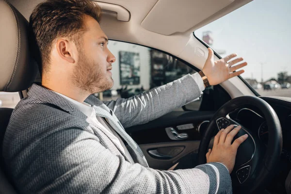 Trafik sıkışıklığındaki kızgın sürücü kurcaladığını ve arabasını bırakmak için gesturing.