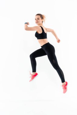 Siyah spor giyim genç sportif sarışın kadın beyaz arka plan üzerinde izole atlama