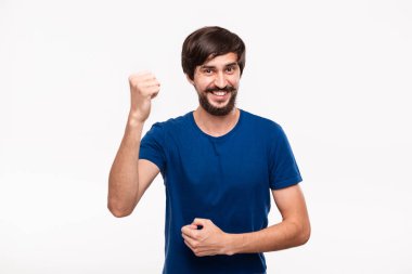 Mavi gömlek bıyıklı genç sakallı brunet sakallı adam kollarını beyaz arka plan üzerinde izole duran zafer jest ifade poz. Başarı kavramı.