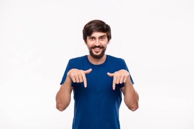 Sakallı mavi gömlekli yakışıklı brunet adam ve bıyıkları parmaklarıyla beyaz arka plan üzerinde izole ayakta işaret. Ürün ve reklam yeri.