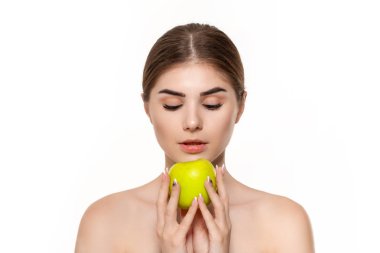 Beyaz arka plan üzerinde izole yüz yakın yeşil elma tutan mutlu bir güzel genç kız yakın çekim portre. Güzellik ve sağlık kavramı.